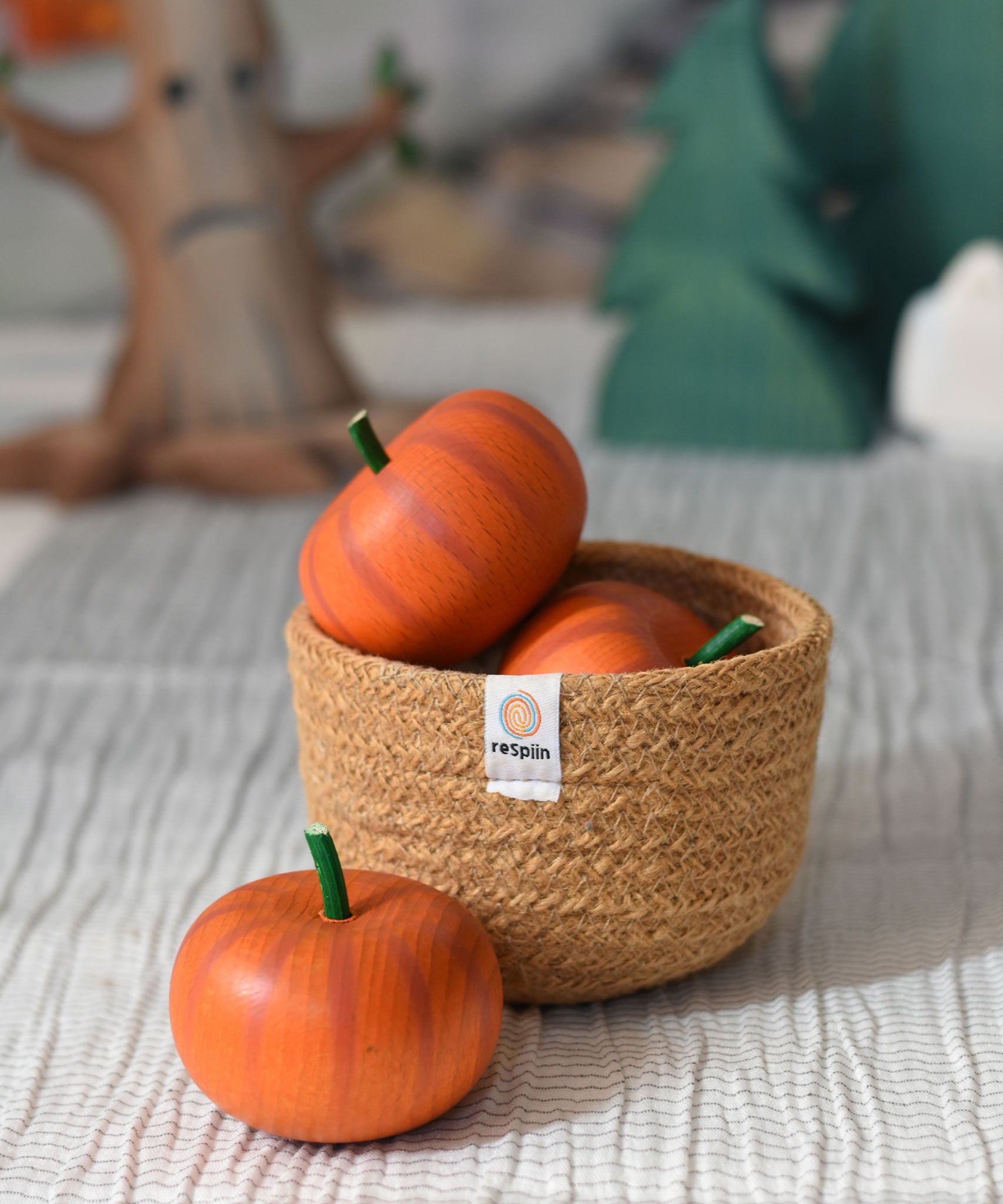 Erzi pumkins placed in a natural jute respiin basket. 