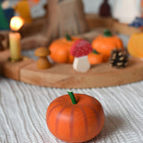 An Erzi pumkin placed on a tablecloth in front of an Autumnal themed celebration ring set up. 
