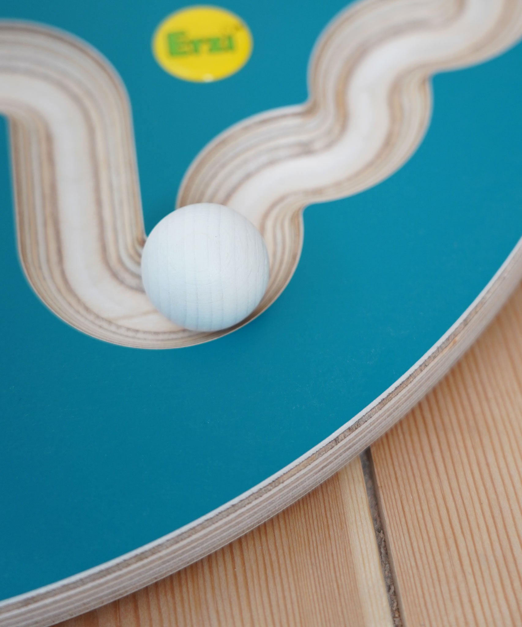 A close up of an Erzi 30mm marble on a trackboard. 