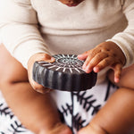 A child holding the amonite bath toy from the Etta Loves sensory bath toy set