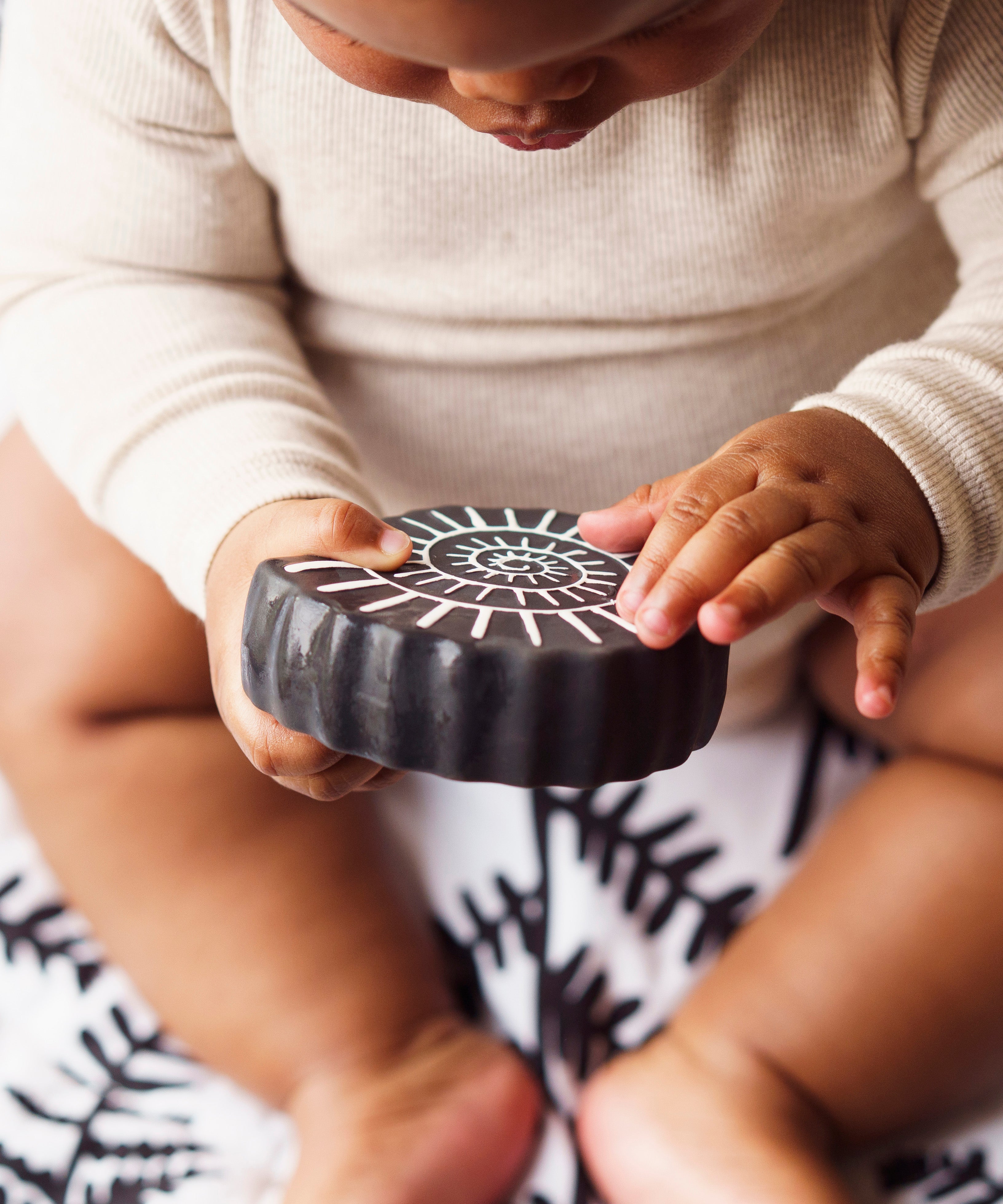 A child holding the amonite bath toy from the Etta Loves sensory bath toy set