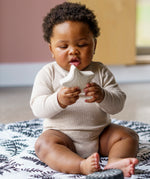 A child playing with  the starfish bath toy from the Etta Loves sensory bath toy set