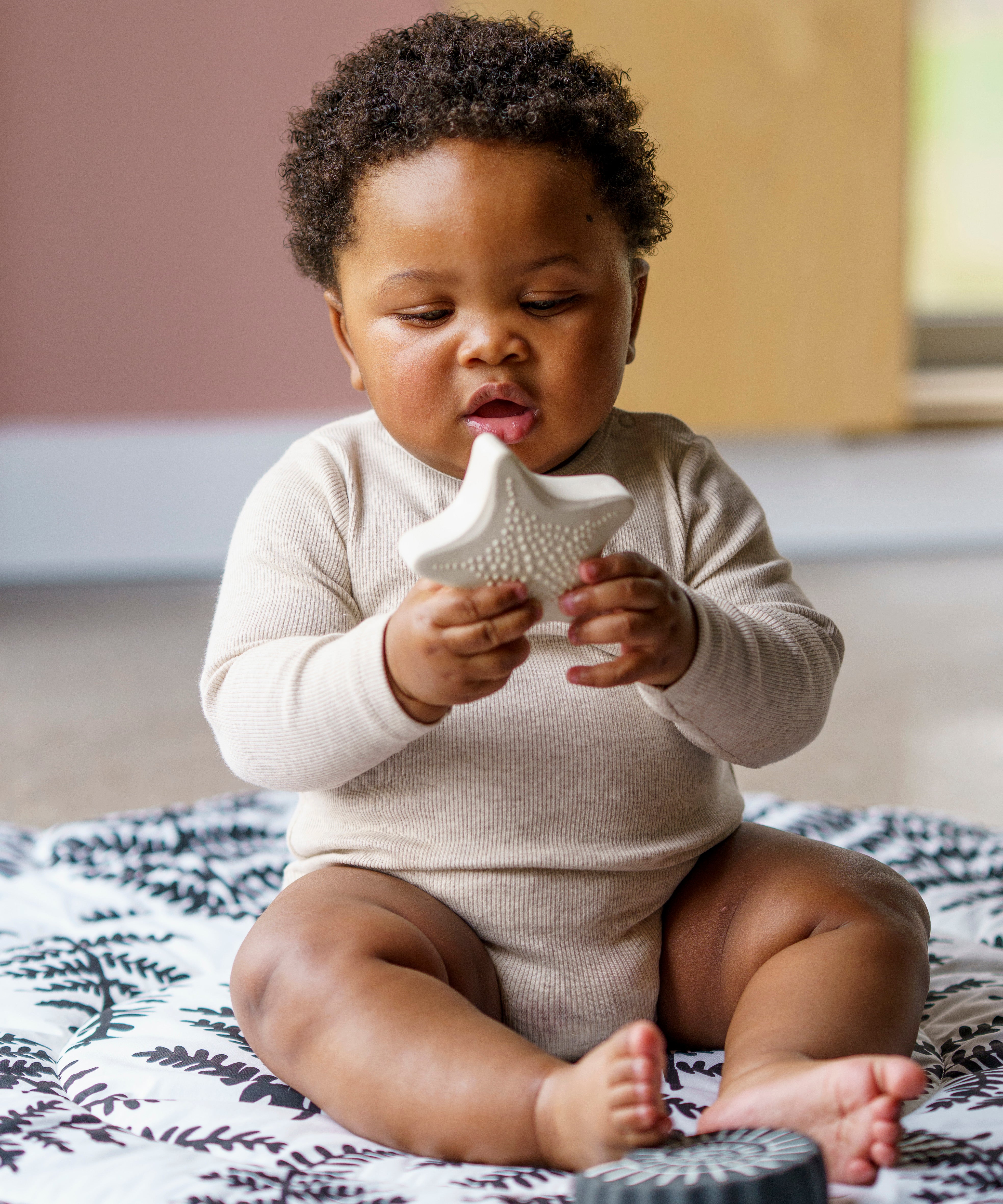 A child playing with  the starfish bath toy from the Etta Loves sensory bath toy set