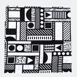 The Etta Loves x Camille Walala XL Muslin Square - Mono folded up into a square on a plain background. 