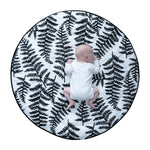 A toddler lying down on colourful Sycamore seed print on the Etta Loves Reversible Organic Cotton Baby Play Mat - Plant Print 