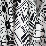 A baby looking up at the Faces print from the Etta Loves Organic Cotton Baby Muslin Squares 3 Pack - Drawing Print