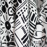 A baby looking up at the Faces print from the Etta Loves Organic Cotton Baby Muslin Squares 3 Pack - Drawing Print