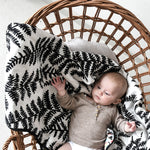  draped over the side of a baby bassinet 