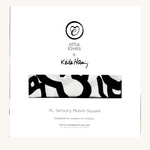 Etta Loves X Keith Haring Extra Large Organic Cotton Baby Muslin Square showing in its white packaging with brand logo  on the front