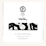 Etta Loves X Keith Haring Extra Large Organic Cotton Baby Muslin Square showing in its white packaging with brand logo  on the front