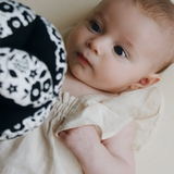 Baby looking at the Etta Loves x Liberty organic cotton sensory grasping ball 