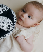 Baby looking at the Etta Loves x Liberty organic cotton sensory grasping ball 