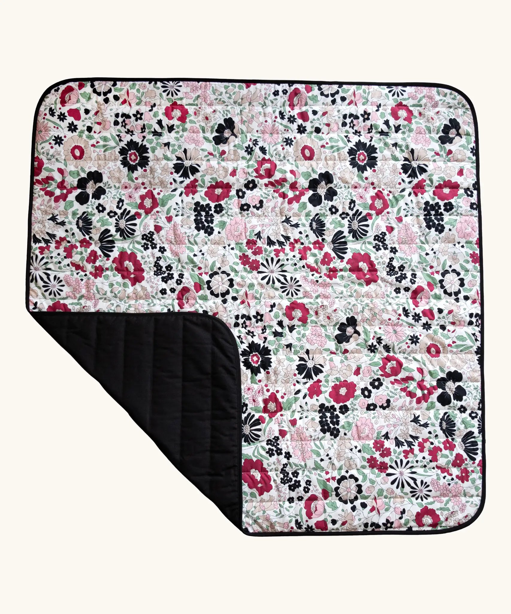 Etta Loves x Liberty organic cotton colourful sensory outdoor playmat showing a repeating floral design and a black reverse panel