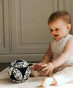 Etta Loves x Liberty organic cotton sensory grasping ball with a black inner, being played with by a child
