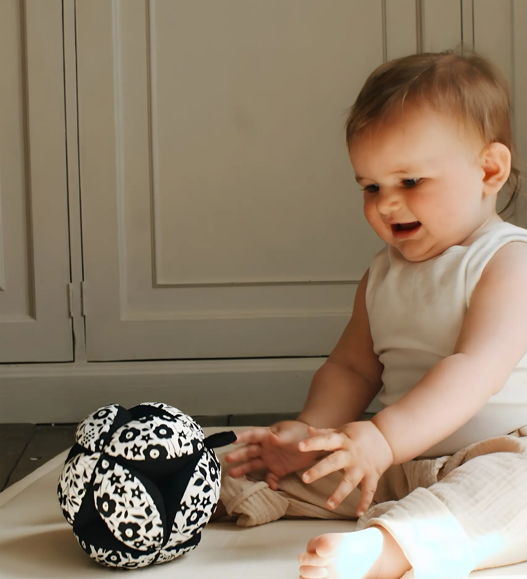 Etta Loves x Liberty organic cotton sensory grasping ball with a black inner, being played with by a child