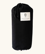 Black cotton bag with a brand patch holding the Etta Loves x Liberty organic cotton sensory monochrome outdoor playmat 