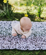 Baby crawling on the Etta Loves x Liberty organic cotton monochrome sensory playmat 