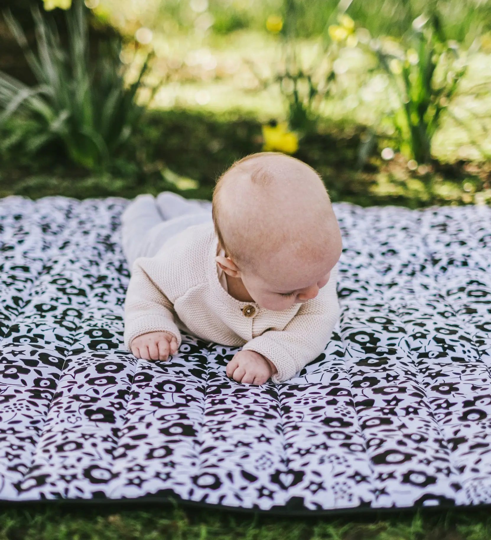 Baby crawling on the Etta Loves x Liberty organic cotton monochrome sensory playmat 