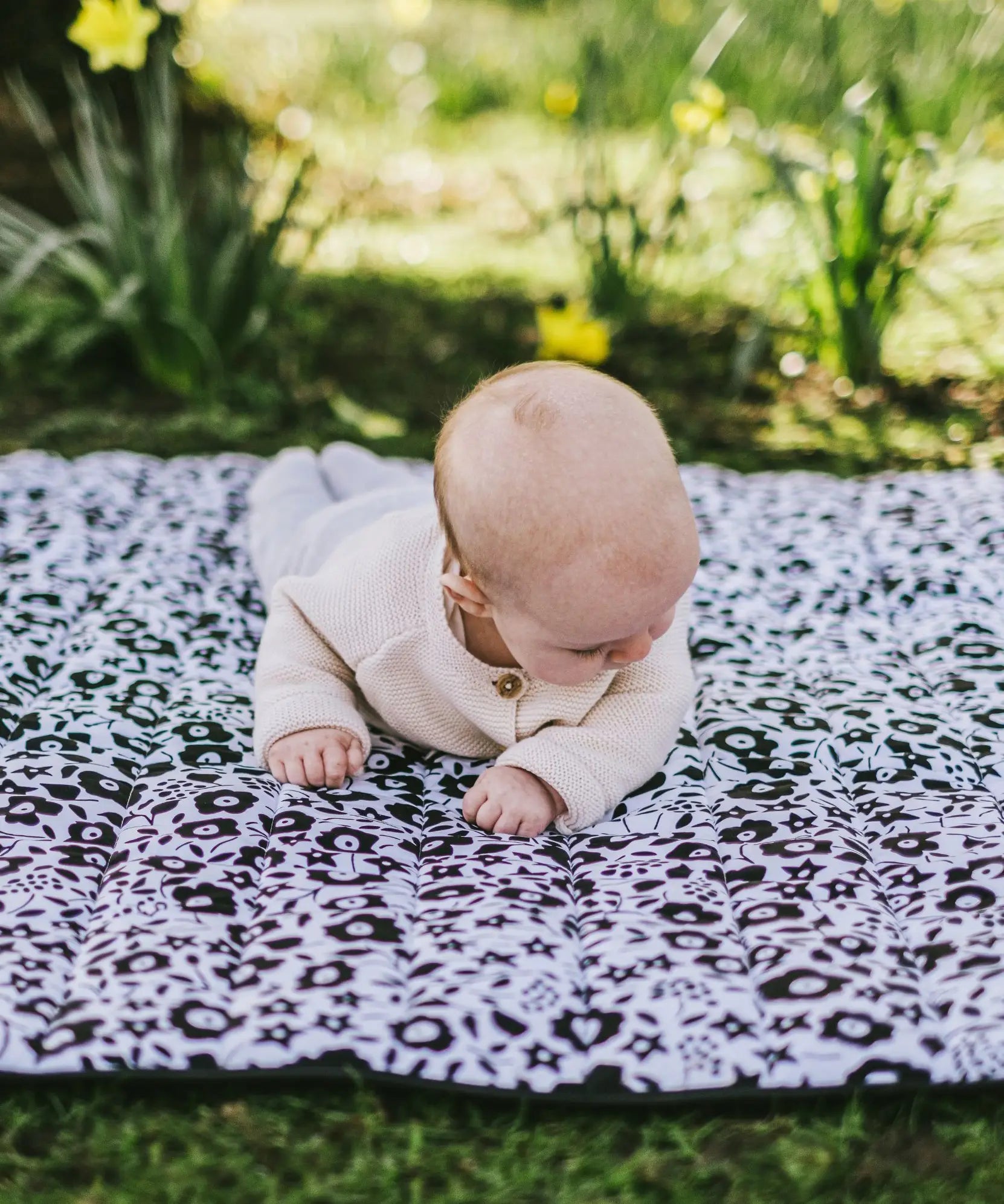 Baby crawling on the Etta Loves x Liberty organic cotton monochrome sensory playmat 