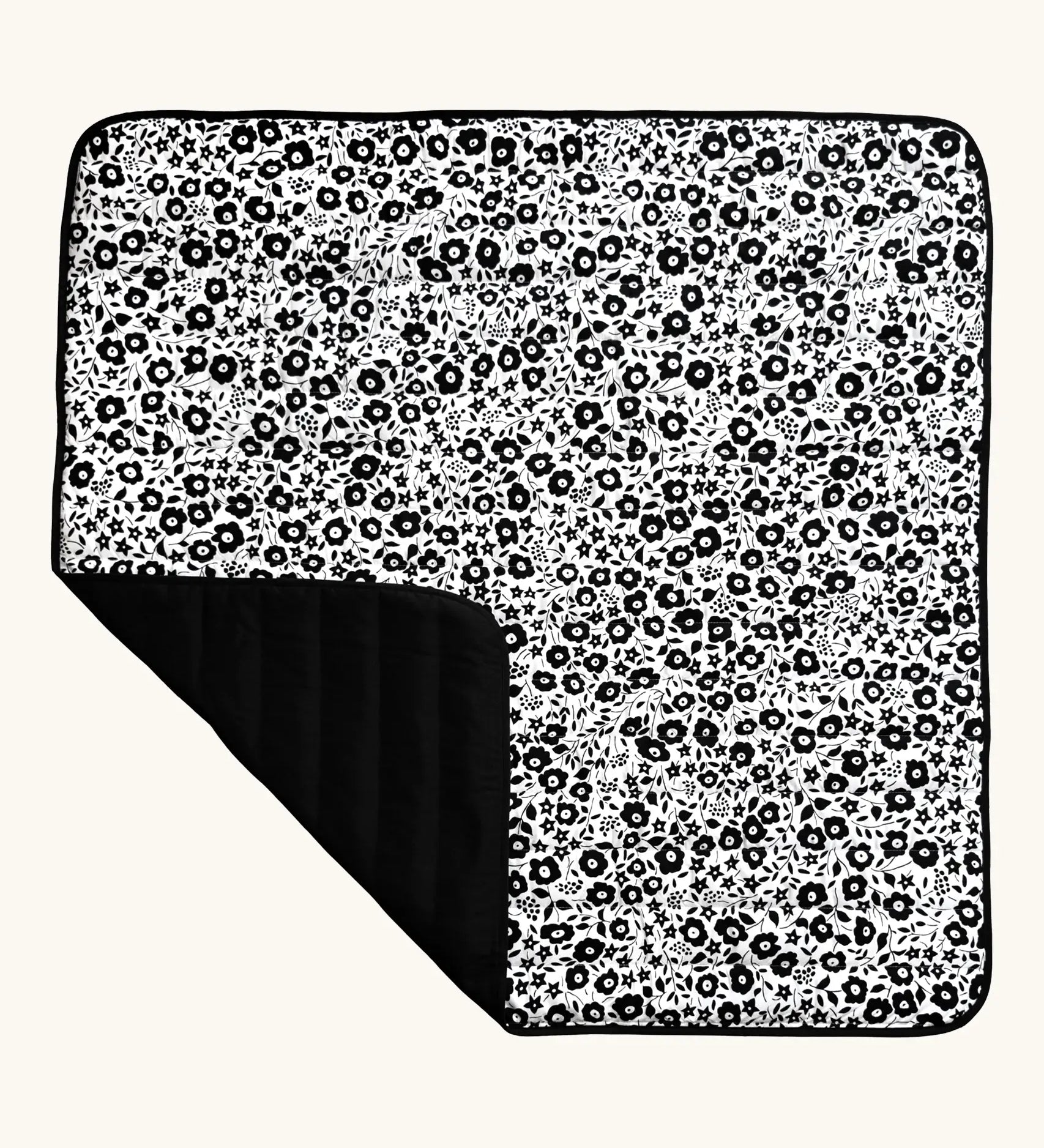 Etta Loves x Liberty organic cotton monochrome sensory outdoor playmat showing a repeating floral design and a black reverse panel