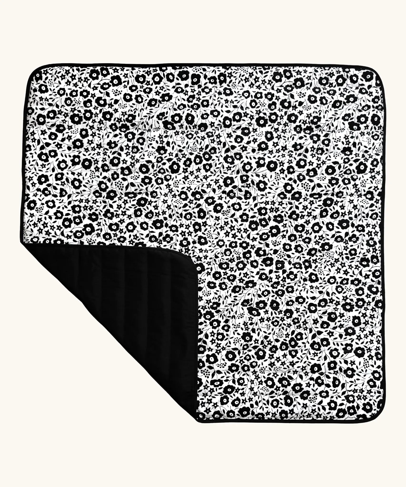 Etta Loves x Liberty organic cotton monochrome sensory outdoor playmat showing a repeating floral design and a black reverse panel