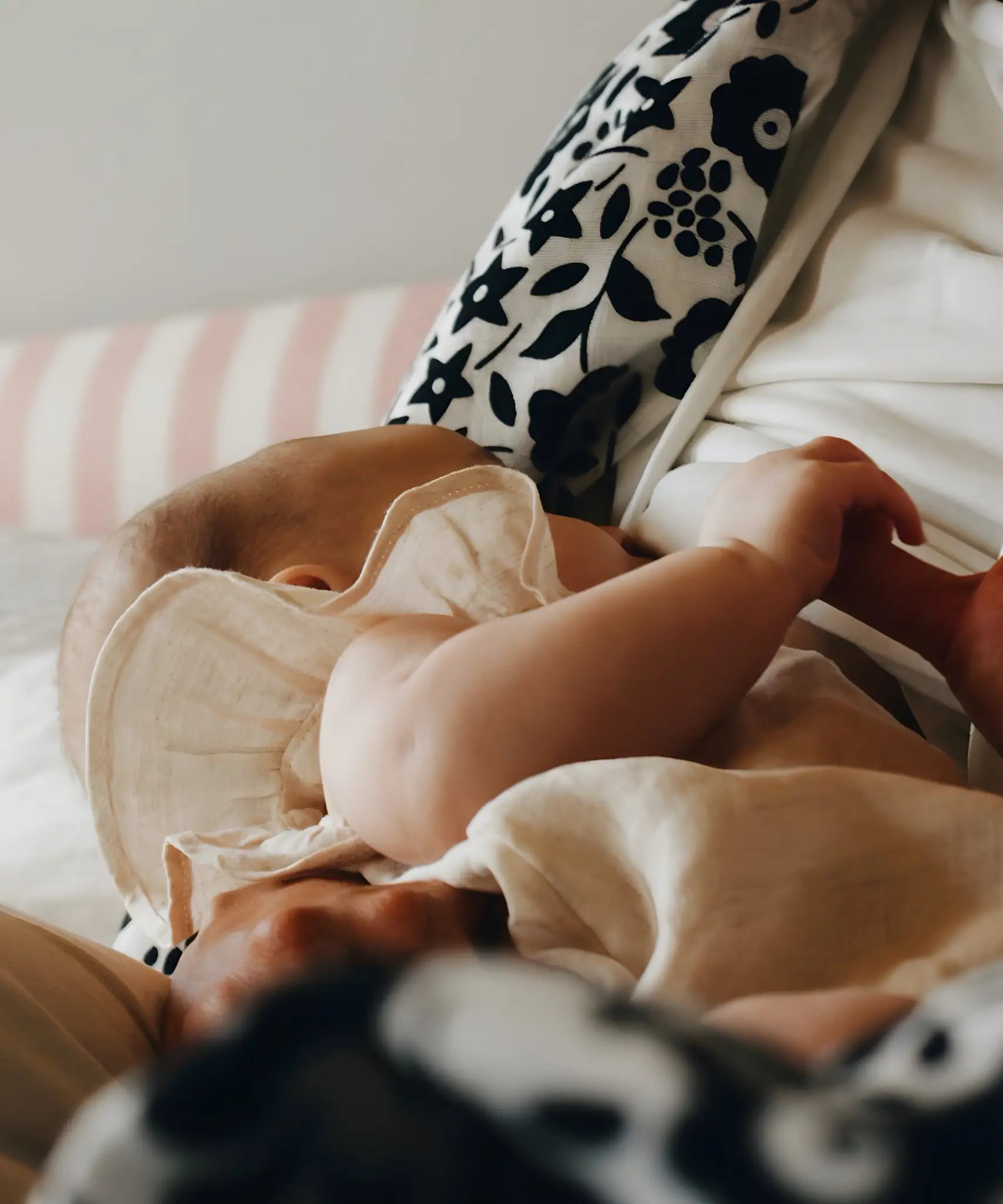 Mother feeding a baby with a Etta Loves x Liberty organic cotton muslin square over the shoulder 