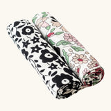 Etta Loves x Liberty muslin squares - 2 Pack. With a monochromatic floral pattern on the left cloth, and a pastel floral design on the right cloth.