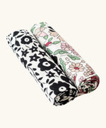 Etta Loves x Liberty muslin squares - 2 Pack. With a monochromatic floral pattern on the left cloth, and a pastel floral design on the right cloth.