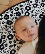 Baby lying on its back on the GOTS organic cotton Etta Loves x Liberty sensory reversible playmat showing the Fairford shadow design