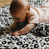 Baby crawling on top of the GOTS organic cotton Etta Loves x Liberty sensory reversible playmat showing the Fairford shadow design