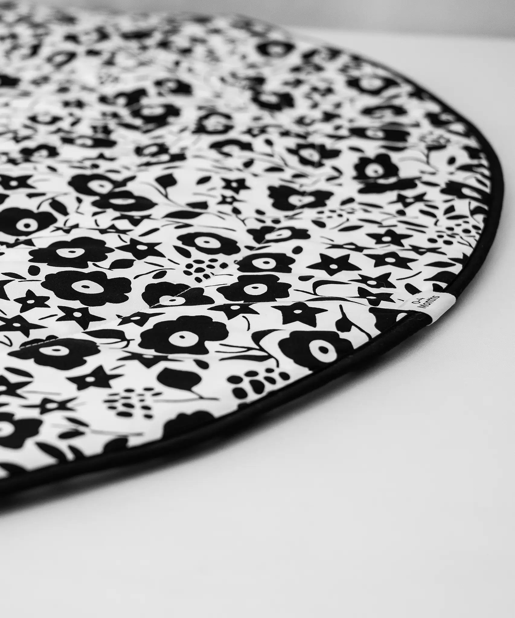 GOTS organic cotton reversible sensory playmat from Etta Loves in collaboration with Liberty laid flat showing the Fairford shadow design with black rim