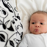A baby looking up at the Lines print from the Etta Loves Organic Cotton Baby Muslin Squares 3 Pack - Drawing Print