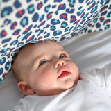A baby looking at the visually stimulating Etta Loves colourful leopard print muslin square.