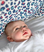 A baby looking at the visually stimulating Etta Loves colourful leopard print muslin square.