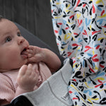 A baby looking up at the colourful Sycamore print on the Etta Loves Organic Cotton Baby Muslin Squares 2 Pack - Fern/Sycamore