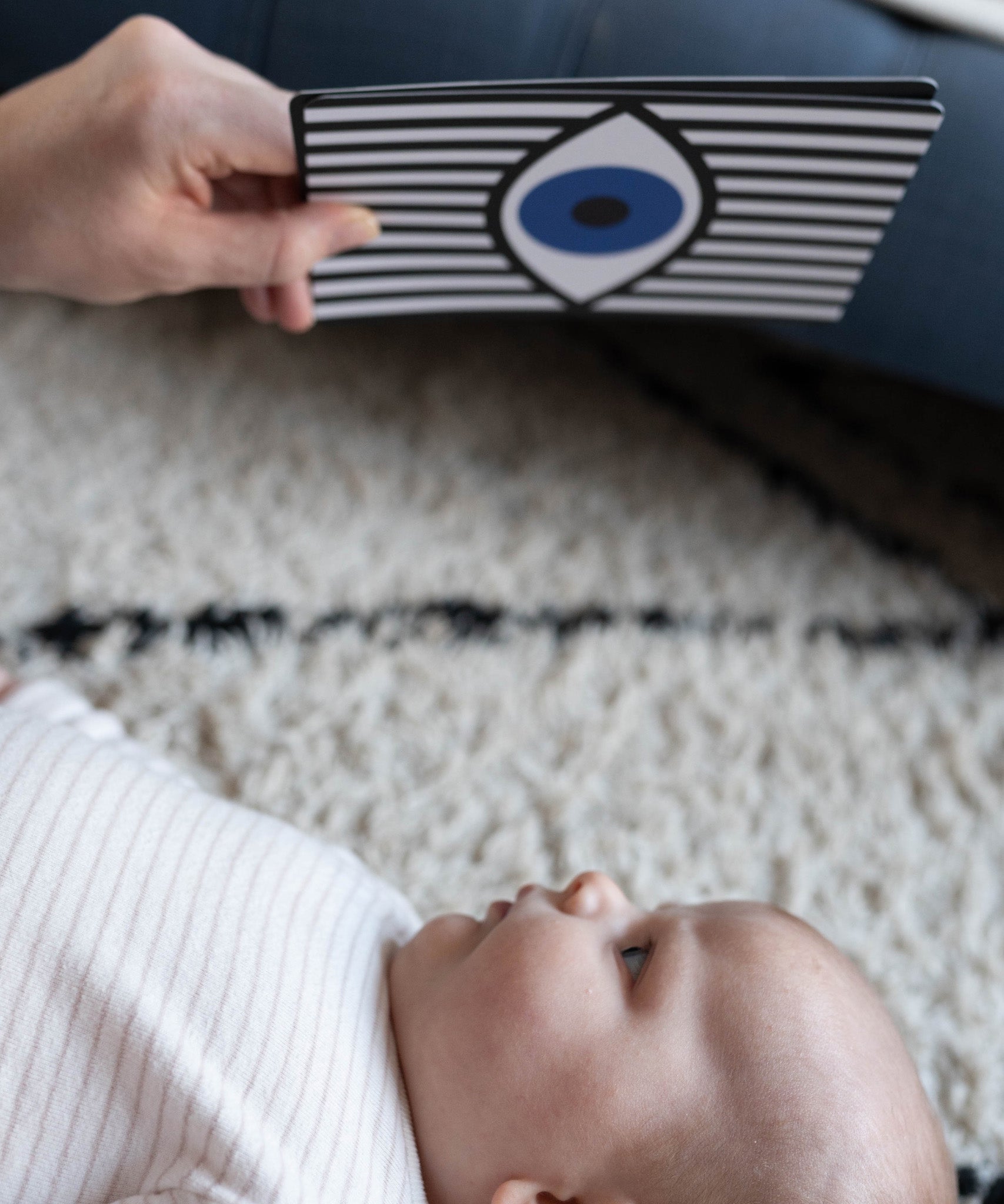 A close up of a parent playing with their child, using the Etta Loves Sensory Positive Affirmation Flash Cards