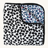 The Etta Loves Reversible Organic Cotton Muslin Blanket - Animal Print, with a fun, black, spotty Dalmatian print on one side, and a colourful Leopard print on the other