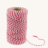 Red and white striped biodegradable cotton baker’s twine on a spool with a loose end, made by Everlasto in Bolton, England.