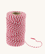 Red and white striped biodegradable cotton baker’s twine on a spool with a loose end, made by Everlasto in Bolton, England.