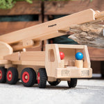 Close up of the Fagus handmade wooden crane toy carrying a small log