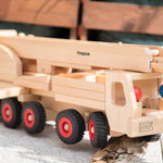 Close up of the Fagus eco-friendly mobile crane toy with its crane down on a grey concrete slab