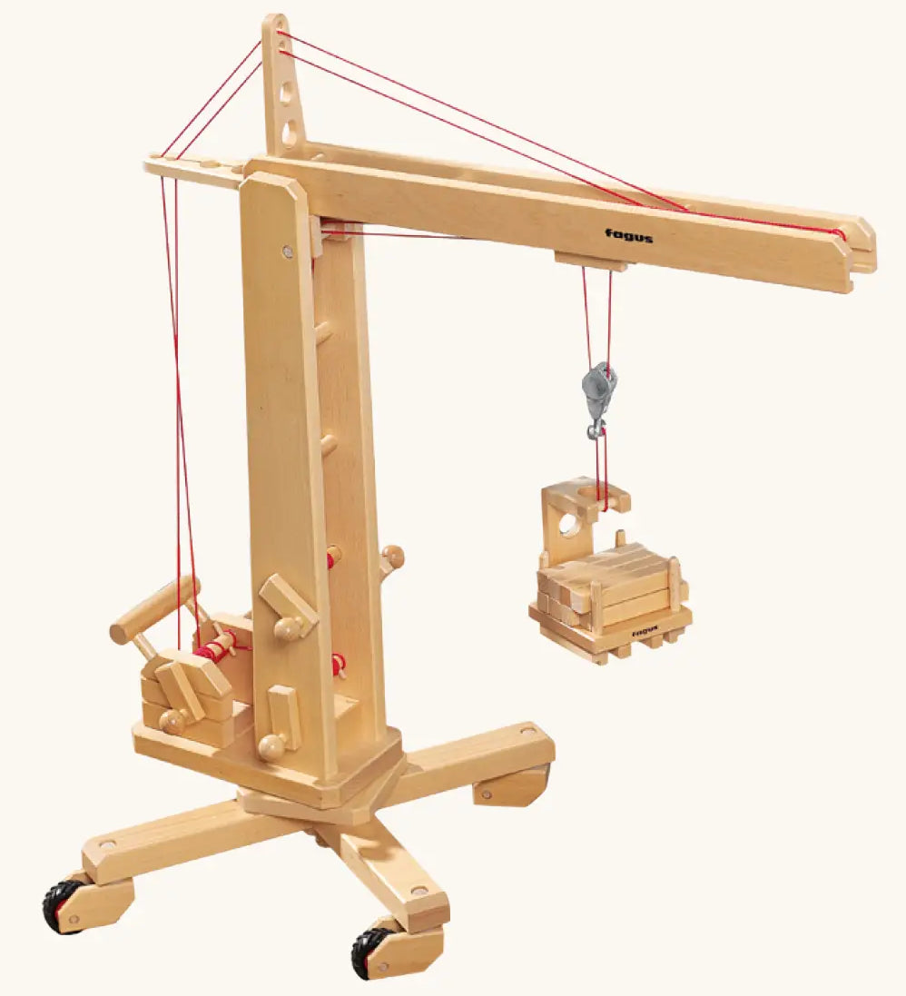 Fagus handmade wooden crane toy. The toy has four wheels on the base.