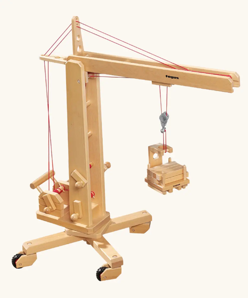 Fagus handmade wooden crane toy. The toy has four wheels on the base.