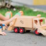 Close up of child pushing the Fagus large garbage truck toy with the sweeper attachment on the front