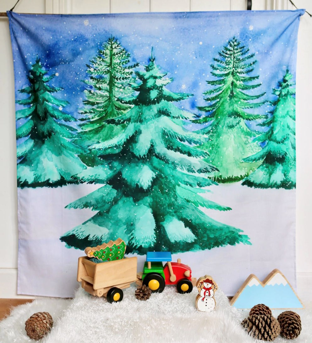 The Wondercloths Christmas Tree Play Cloth in a snowy play scene with the Bajo wooden tractor and Lanka Kade Christmas figures.