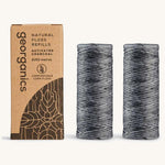 A pair of charcoal floss refills on a cream background with the cardboard box