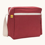 A side angle view of the vintage burgundy coloured Fluf Crossbody Bag. The bag has and off white coloured zip an crossbody strap.