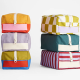 Fluf organic cotton canvas travel bags in different designs, stacked on top of each other.