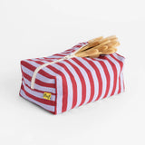Fluf organic cotton travel washbag in Chili Stripe, with bamboo toothbrushes inside.