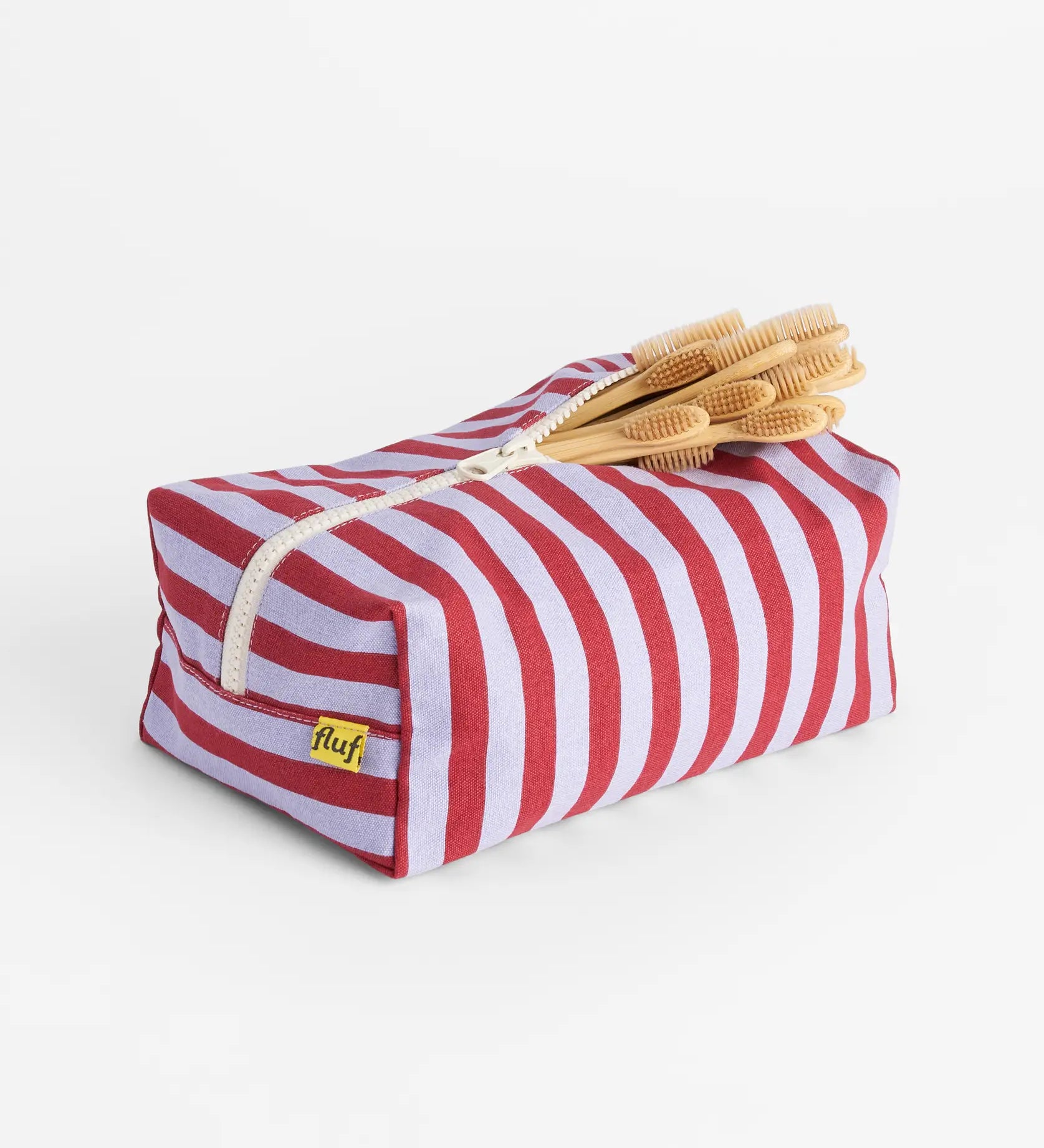 Fluf organic cotton travel washbag in Chili Stripe, with bamboo toothbrushes inside.